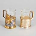 Two russian silver tea glass holders 19th20th c plain cylindrical holder with old cyrillic inscription unidentified maker and assayer cyr mi and md saint petersburg 1878 silver gilt and niel