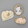 Three carved organic gem brooches carved ivory rose with diamond cluster silver findings chinese carved coral bird and roses in 14k gold foliate mount carved shell cameo depicts woman and bird in