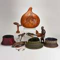 African decorative items include three massai hats two massai neck rests decorated gourd wood figure of a boy bowl beaded earrings and two slingshots with carved heads unmarked largest 16