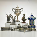 Indopersian silver etc trinket box together with silverplate loving cup musical cigarette box bronze bookends egyptian revival ink stand bronze vase with putto unmarked tallest 13 x 7