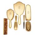 Tiffany  co 18k gold vanity set eight pieces ogee edge raised oval cartouches with interlaced monograms hand mirror 10 34 hair brush 8 1516 garment brush 7 nail buffer on 7 tray sol