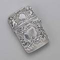 Baroque 800 silver card case cushion shaped raised with foliate scroll and putti hinged with thumb press deployment ca 1900 monogram on reverse austrian and french import marks 3 34 x 2 38
