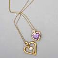 Two 14k yellow gold heart pendants with diamonds bezel set heart shaped amethyst under three stone diamond cluster on 14k yg chain 16 sinuous design centers approx 25 ct round brilliant cut d