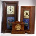 Clocks two ogee clocks with reversepainted panels together with one mantle clock late 19thearly 20th c wood reversepainted glass glass brass one with paper label tallest 30