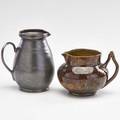 George ohr two small pitchers with ear handles one in gunmetal glaze and one in mottled brown glaze biloxi ms 18951900 both stamped taller 4 14