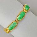 Jade and 22k gold bracelet four translucent mottled green jade lozengeshaped tablets 20  1855 mm x 84  82 mm in textured links finished by curb links marked 24k at least 22k 7 18 32