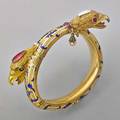 Victorian jeweled enameled eagle bypass bracelet 18k gold twicehinged semispherical tubular form with incised and enameled rococo decorations two chased eagle heads one with opal crown red and g
