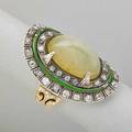 Cats eye chrysoberyl diamond ring oval sugar loaf cats eye 15 cts by formula framed by rows of oec and omc diamonds box set in platinum and a line of green enamel on incised and pierced 14k g
