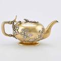 Russian japanesque parcel gilt silver teapot oblate gilt vessel on oval foot vegetal split handle joints applied silver insects and foliage hinged lid surmounted by a salamander ivory insulators