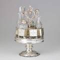 Tiffany  co coin silver revolving railroad cruet square box cars on drumshaped plateau chased repousse grape vine foot applied cast vine border and loop handle six cars support gothic style cut