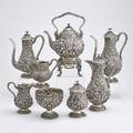 Eight piece sterling repousse coffee service bulbous or pearshaped vessels profusely decorated with deeply chased fruit and floral decorations floral finials kettle on branchfooted stand 15 th