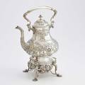 Jones ball and poor coin silver kettle on stand pearshaped body chased with flowers and foliage scroll and acanthus spot and handle gadrooned stand with flowers and cherubs ivory insulators bost