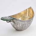 Silver boat shaped presentation punch bowl decorated with panslavic interlacing birds and mythological beasts cyrillic inscription below rim dragon handle with split terminus surmounted by nephrit