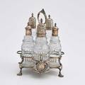 George iii silver cruet set london 1768 cruet stand supports five cut glass bottles stag crest on ribbon cartouche twisted oval finials stand with shell feet and loop handle frame and two bottl