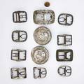 Thirteen buckles or buttons includes silver iron brass bronze 18th19th c largest buckle 3 23 largest silver button 3 18
