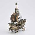 Continental silver nef designed as a wheeled ship under sail twelve sailors inhabit the deck and rigging the hull raised with dolphins on waves dragon mast head ca 1890 12 14 x 8 34 18 ot