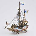 Viennese enameled gilt silver nef in the form of a wheeled ship under sail inhabited by ten sailors enameled with painted polychrome mythological and romantic imagery late 19th c marked lp 9
