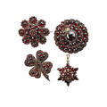 Collection of victorian bohemian garnet jewelry four pieces three brooches and a pendant in circular star burst floral and fourleaf clover forms gilt metal ca 18901900 unmarked largest 1 1