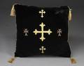 A BLACK VELVET PILLOW WITH CENTRAL CRUCIFIX