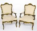 64 PAIR OF ROCOCO STYLE CARVED AND EBONIZED ARM CHAIRS