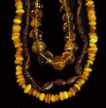 487 GROUP OF THREE CARVED AMBER BEAD NECKLACES