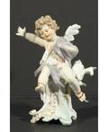 A MEISSEN FIGURINE OF A SEATED ANGEL WITH SKATES
