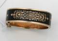A Ladys Victorian Yellow Gold and Black Enamel Hinged Bangle Bracelet