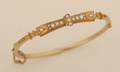 A Ladys Victorian Etruscan Revival Yellow Gold and Seed Pearl Hinged Bangle Bracelet