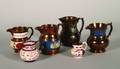 A Collection of Four Copper Lustre Jugs