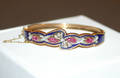A Ladys Yellow Gold Silver Pink Sapphire Diamond and Blue Enamel Hinged Bracelet