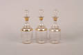 A Set of Three Parcel Gilt Decanters