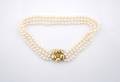 An 18 Karat Yellow Gold and Three Strand Cultured Pearl Necklace