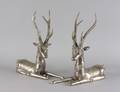 A Pair of Silvered Metal Figures of Recumbent Deer
