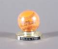 BASEBALL An orange baseball autographed by Charlie O Finley