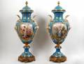 PAIR OF BRASS MOUNTED PORCELAIN URNS AND COVERS