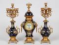 THREE PIECE BRASS AND PORCELAIN CLOCK GARNITURE
