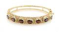 A 14 Karat Yellow Gold and Garnet Hinged Bangle Bracelet