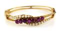 A 14 Karat Yellow Gold Ruby and Seed Pearl Bangle Bracelet