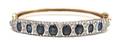 A 14 Karat Two Tone Gold Sapphire and Diamond Hinged Bangle Bracelet