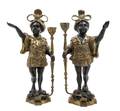 A Pair of Patinated and Gilt Bronze Figural Candlesticks