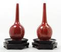 A Pair of Red Ceramic Bottle Form Vases