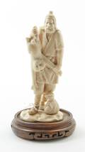 A Japanese Carved Ivory Figure of a Man Catching a Monkey