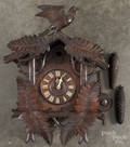 Black Forest carved cuckoo clock with a bird crest