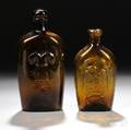 Two Amber Blownmolded Pictorial Glass Flasks