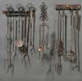 Three Wrought Iron Wallmounted Racks with Thirteen Wrought Iron Utensils