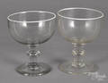 Two colorless glass footed bowls
