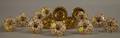 Set of Four Pressed Brass Curtain Tiebacks and a Set of Ten Gilt Porcelain Curtain Tiebacks
