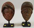 Two IgboIgbostyle Carved Wooden African Masks on Stands