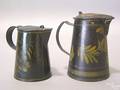 Two black toleware syrup pitchers 19th c