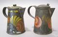 Two black toleware syrup pitchers 19th c
